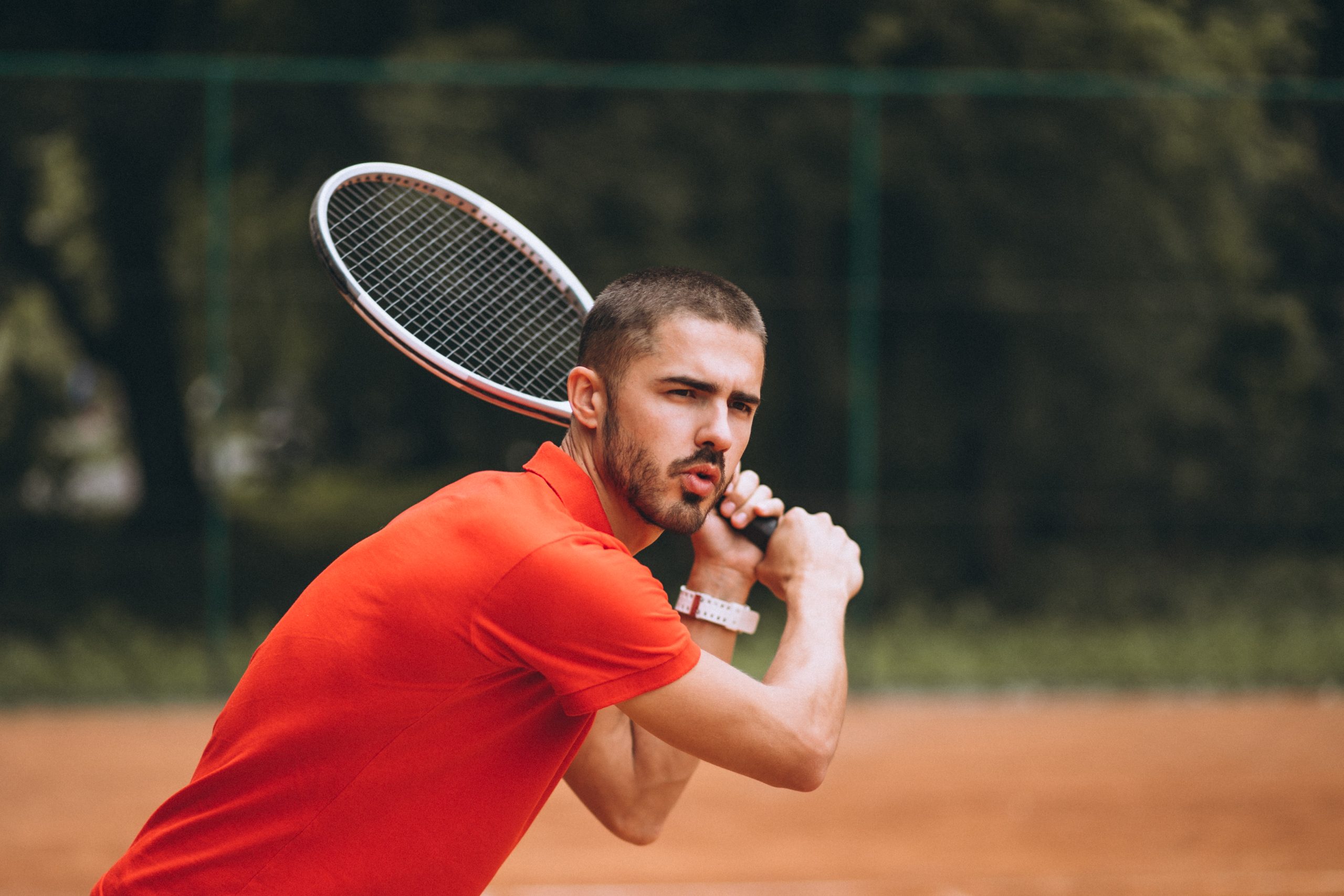 Young male tennis player at the court